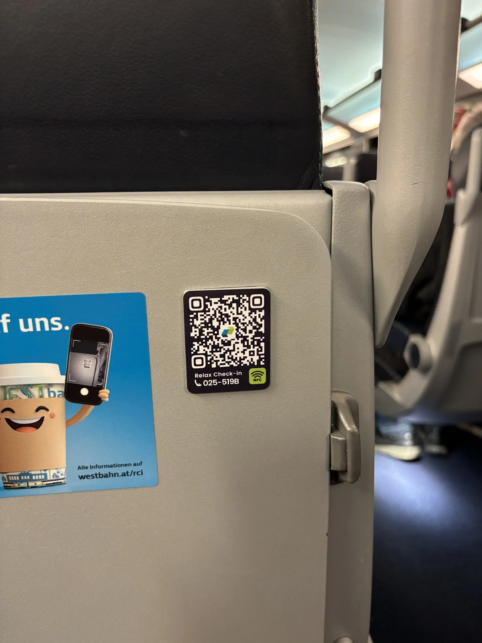 a slightly raised NFC tag with a QR code and the train/seat number printed on it has been glued over the existing metal qr code plate